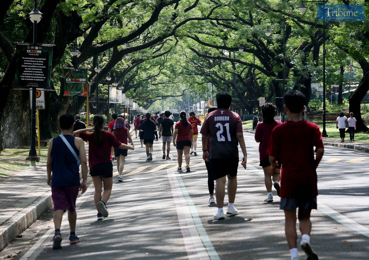 Joggers enjoy the morning sun around the academic oval at the University of the Philippines Diliman in Quezon City, Wednesday, 30 April 2025.
