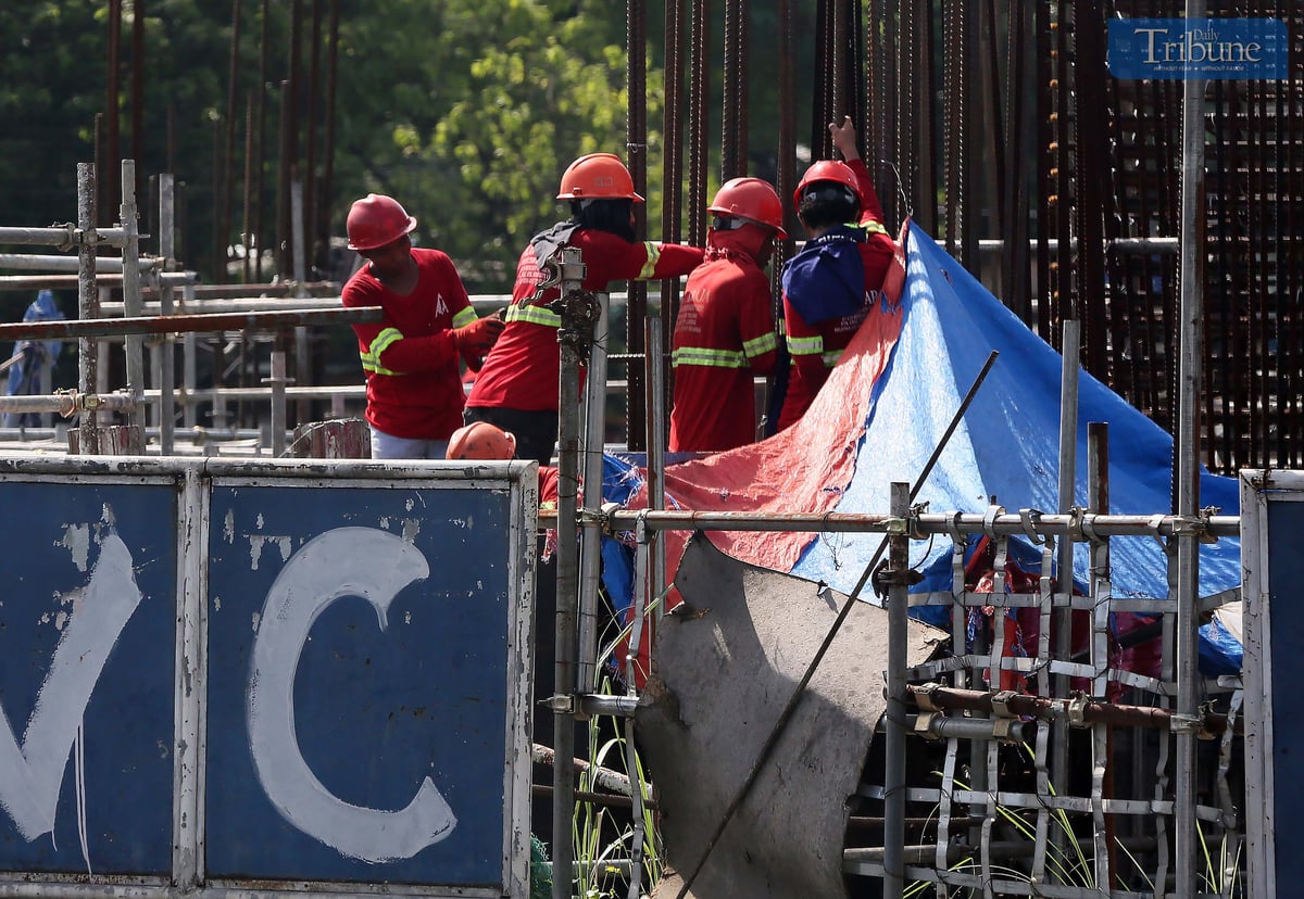 Construction workers at the Metro Rail Transit (MRT-7) site along Commonwealth Avenue in Quezon City work on Wednesday, ahead of the Labor Day celebration.