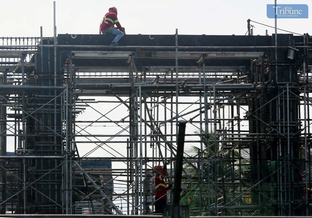 Construction workers at the Metro Rail Transit (MRT-7) site along Commonwealth Avenue in Quezon City work on Wednesday, ahead of the Labor Day celebration.