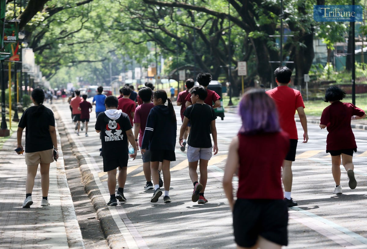 Joggers enjoy the morning sun around the academic oval at the University of the Philippines Diliman in Quezon City, Wednesday, 30 April 2025.