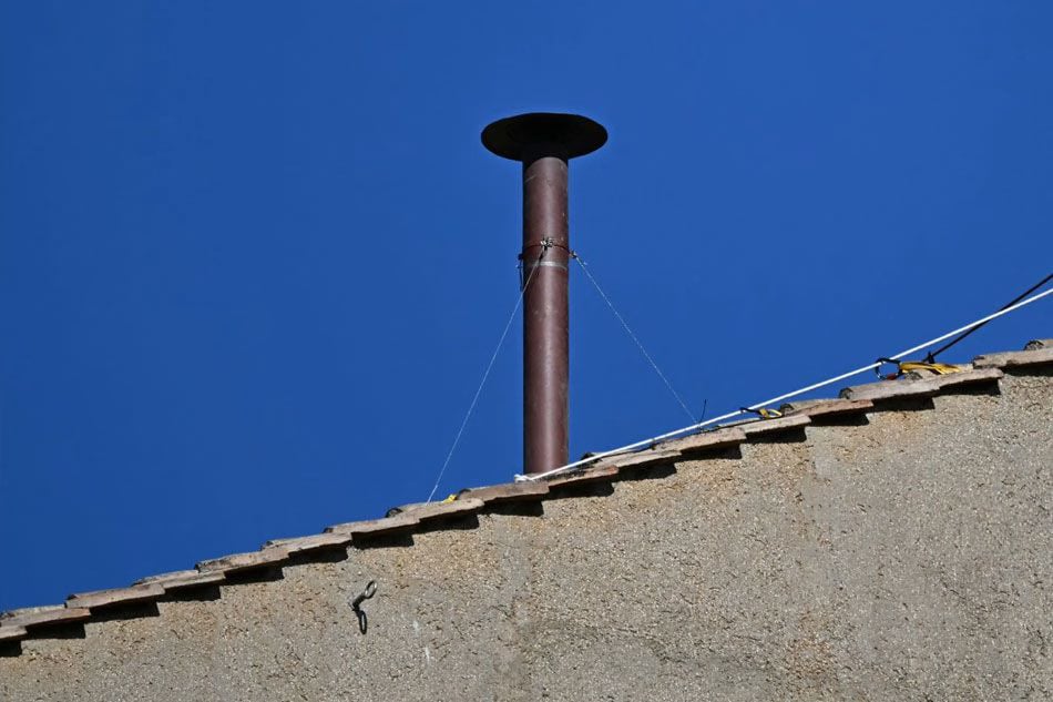 Workers install chimney for conclave 