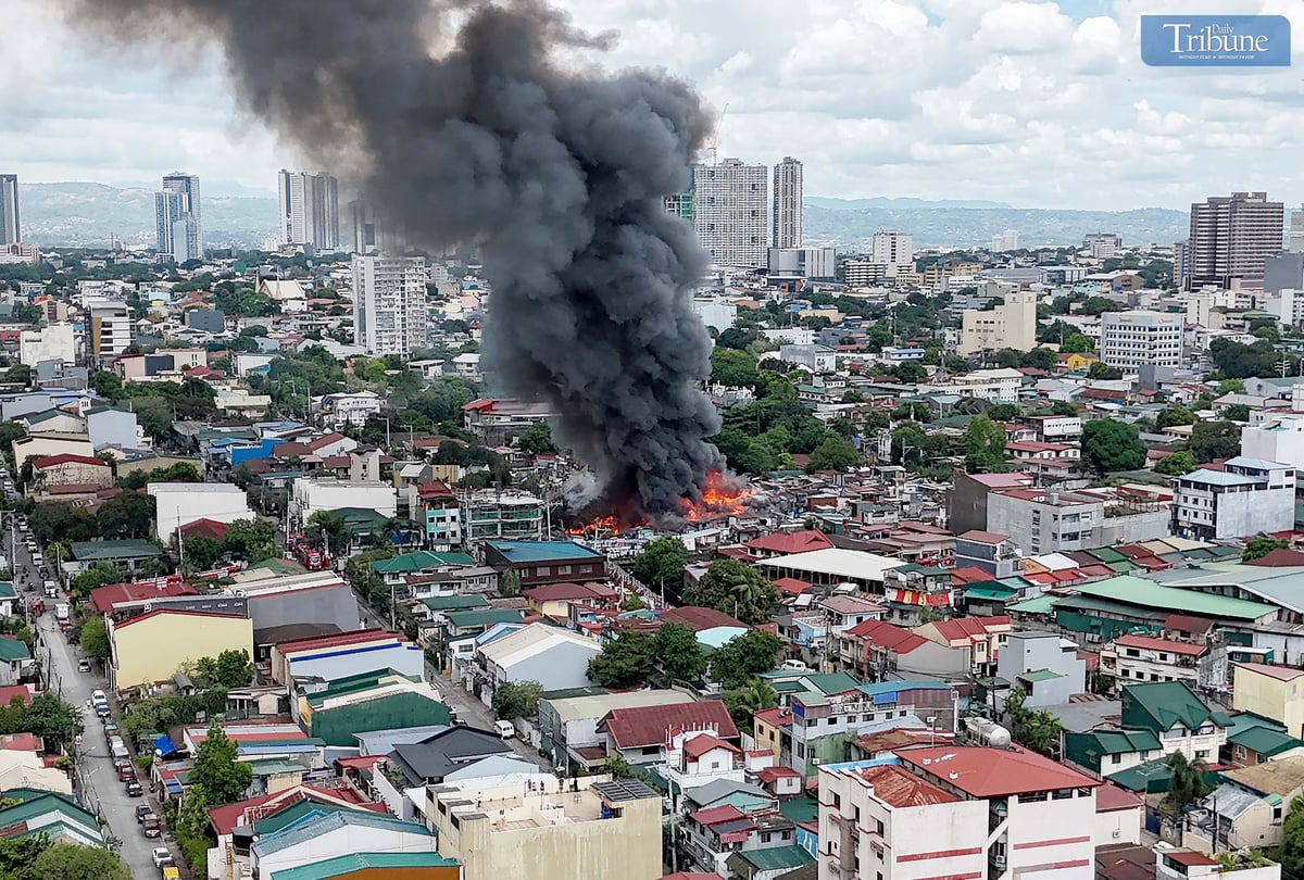 Thick smoke rises from a fourth-alarm fire near Cambridge Street and Ermin Garcia, Barangay E. Rodriguez, Quezon City, on Monday, 5 May 2025.