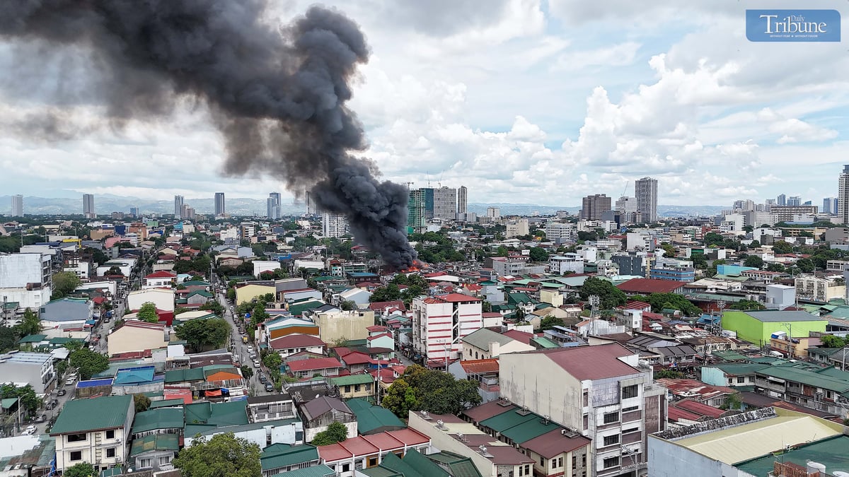 Thick smoke rises from a fourth-alarm fire near Cambridge Street and Ermin Garcia, Barangay E. Rodriguez, Quezon City, on Monday, 5 May 2025.