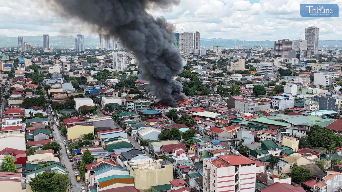 Thick smoke rises from a fourth-alarm fire near Cambridge Street and Ermin Garcia, Barangay E. Rodriguez, Quezon City, on Monday, 5 May 2025.