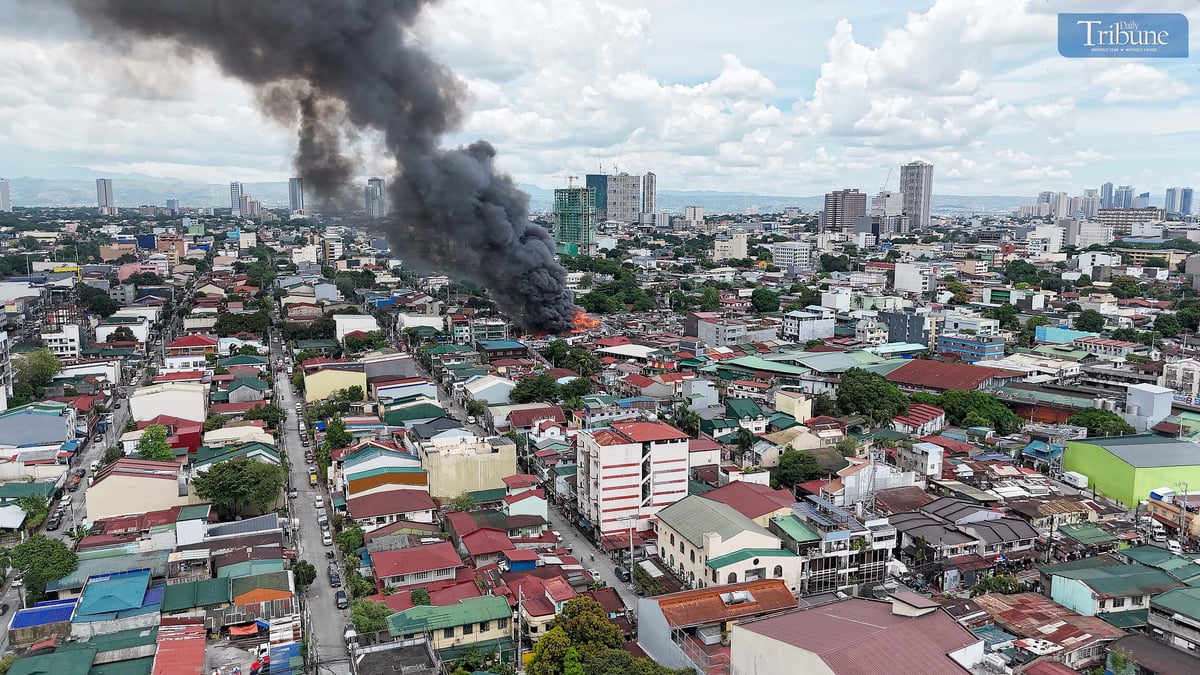 Thick smoke rises from a fourth-alarm fire near Cambridge Street and Ermin Garcia, Barangay E. Rodriguez, Quezon City, on Monday, 5 May 2025.