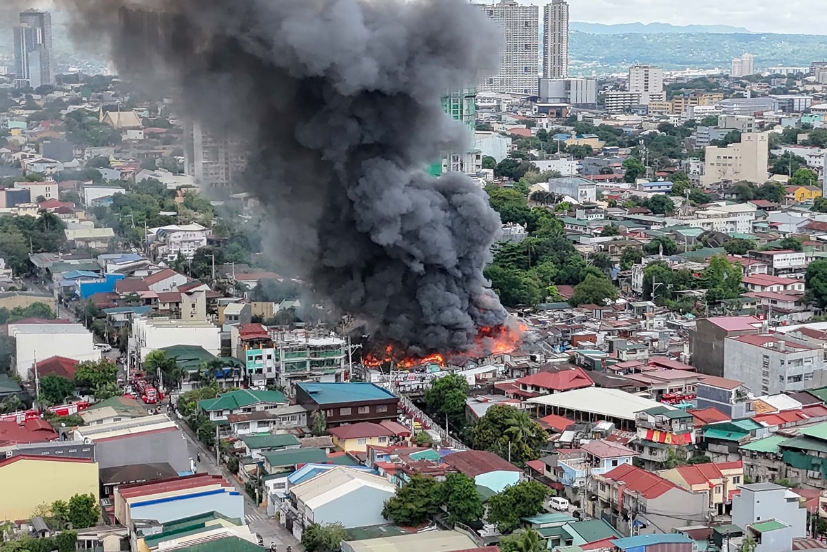 Thick smoke rises from a fourth-alarm fire near Cambridge Street and Ermin Garcia, Barangay E. Rodriguez, Quezon City, on Monday, 5 May 2025.