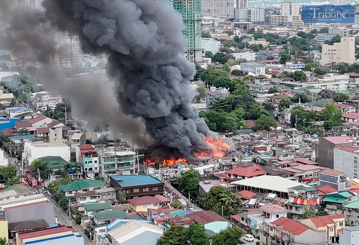 Thick smoke rises from a fourth-alarm fire near Cambridge Street and Ermin Garcia, Barangay E. Rodriguez, Quezon City, on Monday, 5 May 2025.