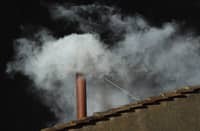 White smoke billows from the chimney atop the Sistine Chapel roof, signaling the successful election of a new pope during the 2013 conclave at the Vatican.