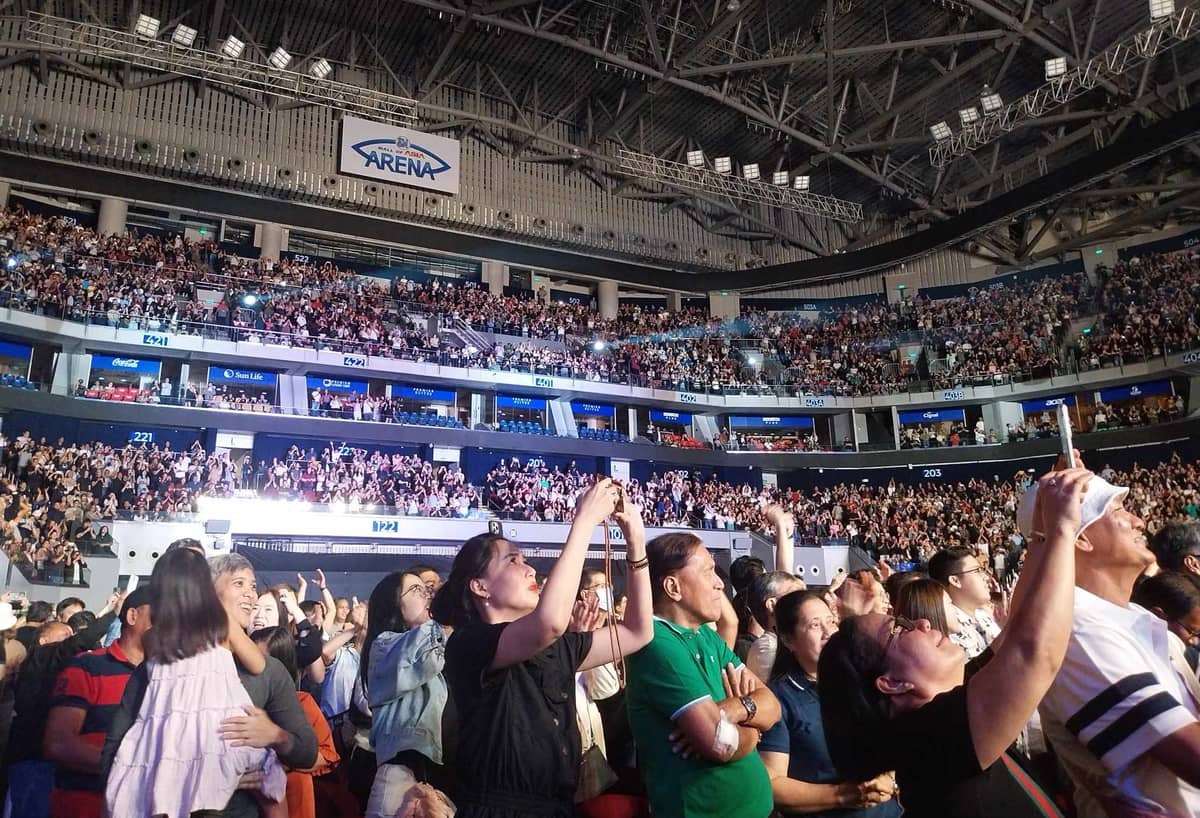 Fans at the SM Mall of Asia Arena cheer with emotion as they applaud the band’s performance.