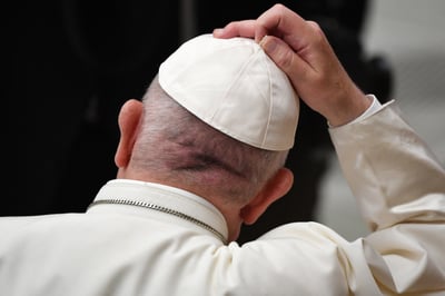 Pope Francis adjusts his white zucchetto (skullcap) during the weekly general audience at Paul VI Hall in the Vatican on 18 December 2019.
