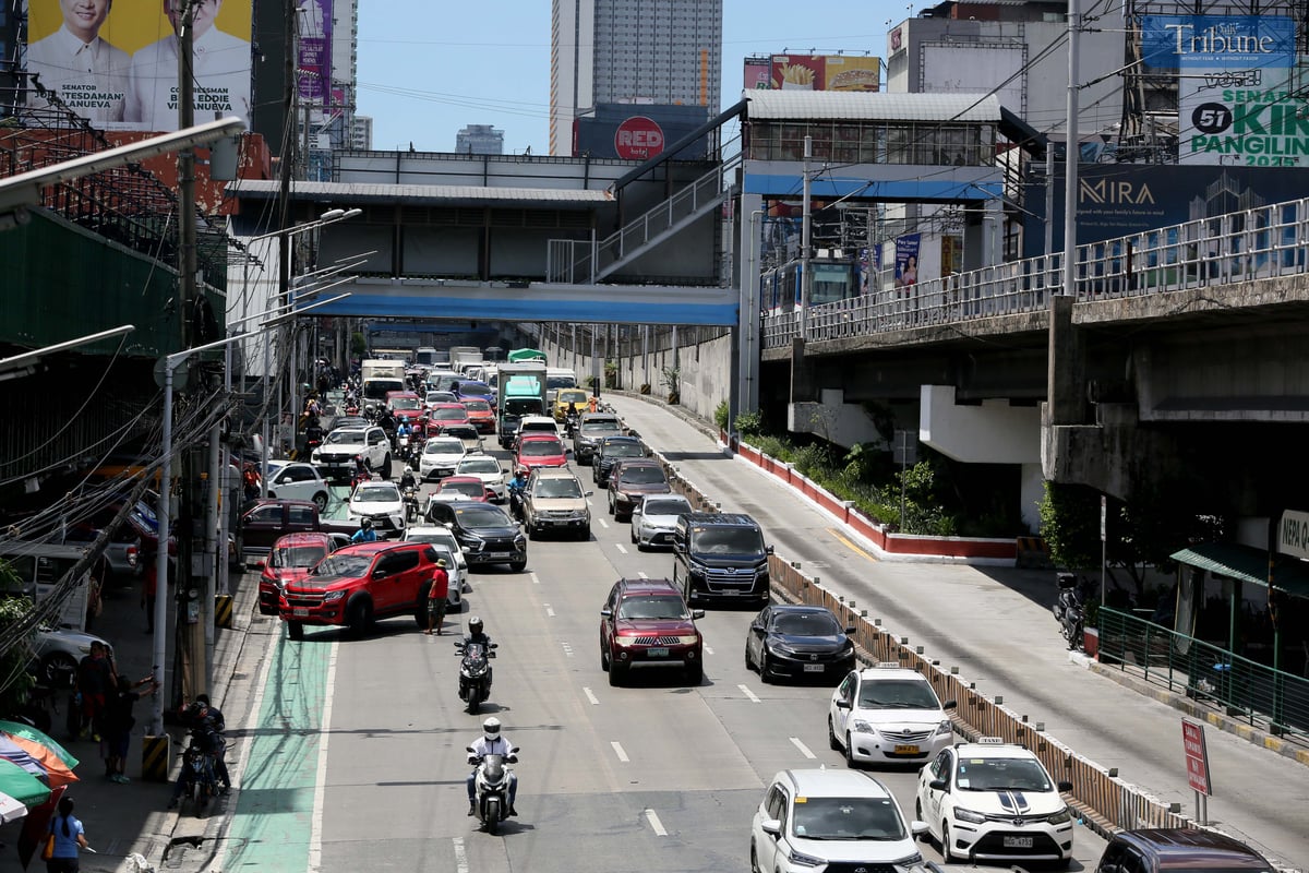 Moderate traffic builds up along EDSA near the provincial bus terminals in Cubao, Quezon City on 10 May 2025, as travelers head out two days before the national elections. MRT-3 trains and billboards loom above the roadway.