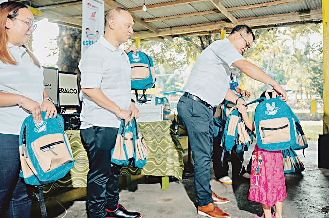 An opportunity to give back. Meralco Chief Operating Officer, Engr. Ronnie Aperocho (rightmost), led the distribution of school kits to students of M. Roxas Elementary School where he attended school four decades ago. He was joined by OMF President Jeffrey Tarayao and Meralco employee volunteers.