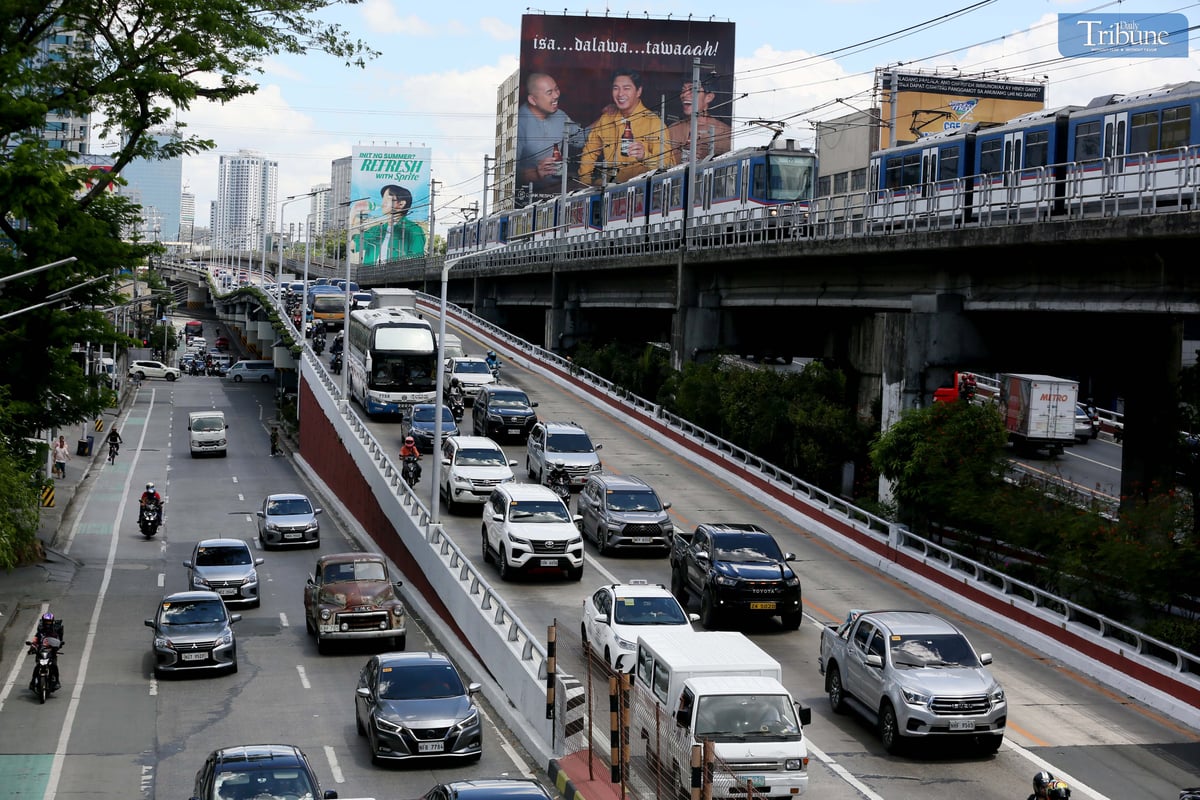 Moderate traffic builds up along EDSA near the provincial bus terminals in Cubao, Quezon City on 10 May 2025, as travelers head out two days before the national elections. MRT-3 trains and billboards loom above the roadway.
