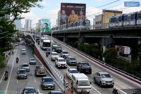 Moderate traffic builds up along EDSA near the provincial bus terminals in Cubao, Quezon City on 10 May 2025, as travelers head out two days before the national elections. MRT-3 trains and billboards loom above the roadway.