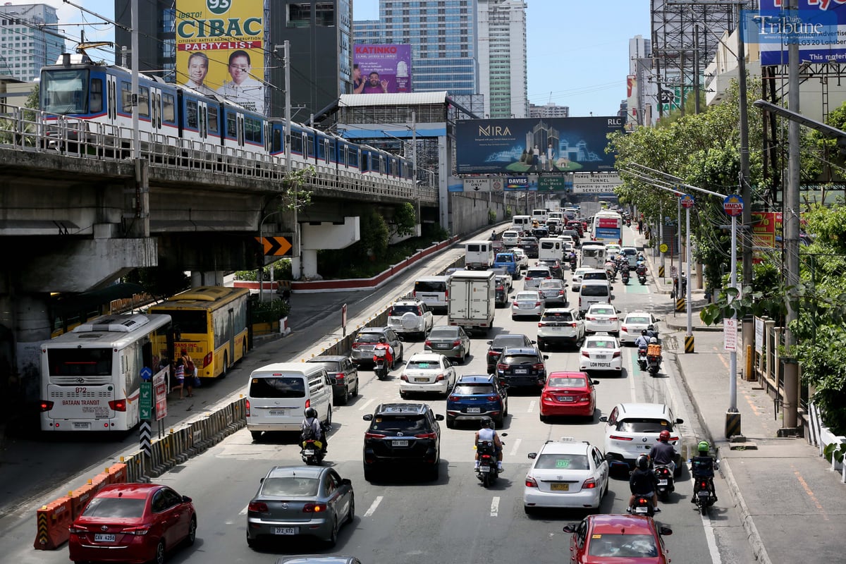 Moderate traffic builds up along EDSA near the provincial bus terminals in Cubao, Quezon City on 10 May 2025, as travelers head out two days before the national elections. MRT-3 trains and billboards loom above the roadway.