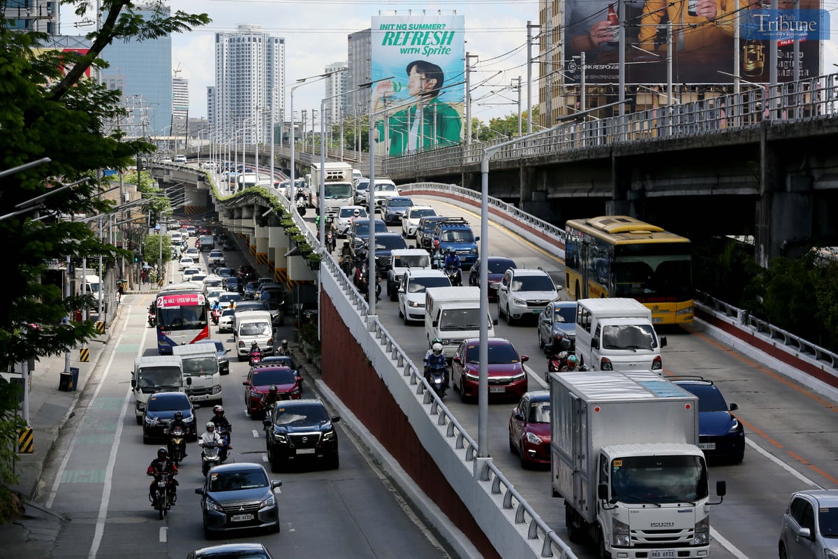 Moderate traffic builds up along EDSA near the provincial bus terminals in Cubao, Quezon City on 10 May 2025, as travelers head out two days before the national elections. MRT-3 trains and billboards loom above the roadway.