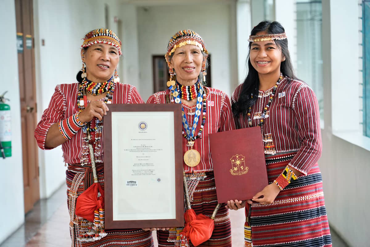 Manlilikha ng Bayan Amparo Balansi Mabanag (center), Ga’dang embroiderer, wearing her GAMABA medallion.