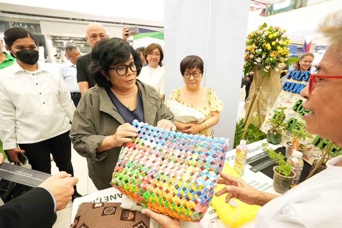 A seller presents Environment and Natural Resources Secretary Loyzaga with products made from recycled materials.