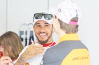 Lewis Hamilton of Great Britain and Scuderia Ferrari talks with Oscar Piastri of Australia and McLaren prior to the F1 Grand Prix of Miami.
