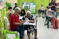 Senior citizens in Paltok Elementary School in Quezon City cast their votes, with the help of their relatives, on Monday.