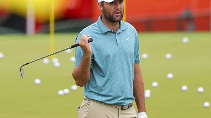 World number one Scottie Scheffler of the United States warms up at the driving range on the rainy first practice day for the 107th PGA Championship at Quail Hollow