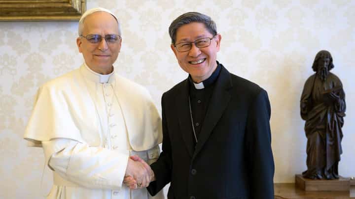 Pope Leo XIV shakes hands with Cardinal Luis Antonio Tagle during a private audience at the Vatican on 16 May 2025. A statue of a bearded figure holding a book stands in the background.