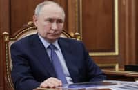Russian President Vladimir Putin sits at a desk during a meeting with Promsvyazbank’s CEO at the Kremlin in Moscow on 15 May 2025, in a pool photograph released by Russian state agency Sputnik.