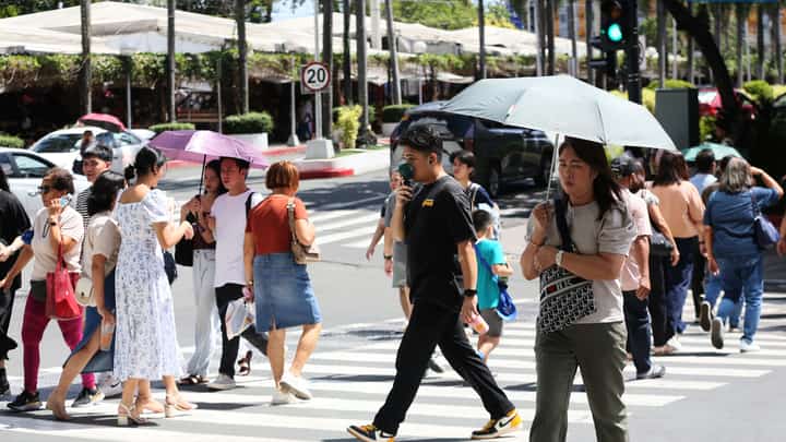 Pedestrians shield themselves from the scorching sun with umbrellas in Quezon City on Monday, 19 May 2025. According to PAGASA, 27 areas across the country are experiencing a “danger-level” heat index of 42°C and above, including Quezon City. Temperatures soared as high as 45°C in Aparri, Cagayan, and Dagupan City, Pangasinan.