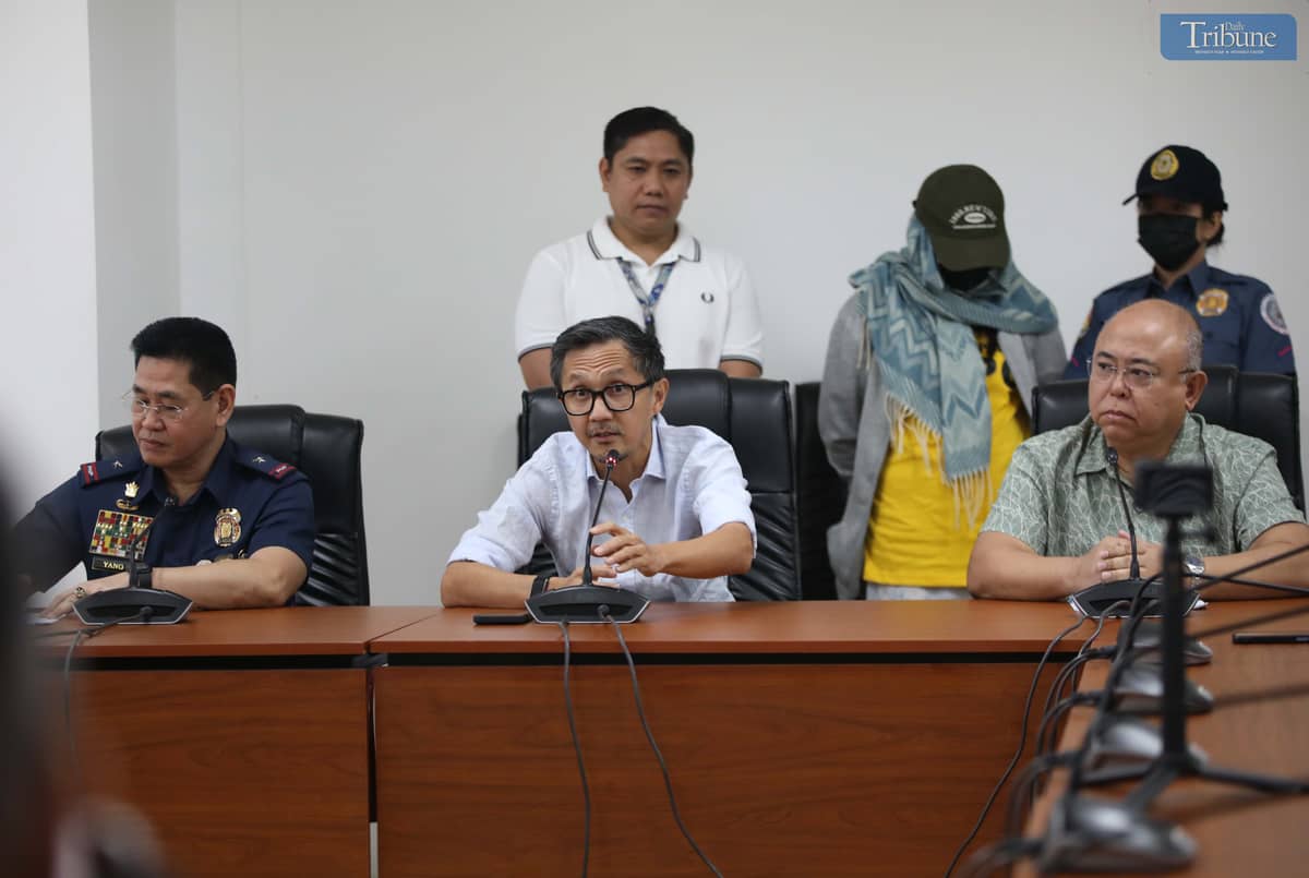 Transport Secretary Vince Dizon, LTO Chief Asec. Vigor Mendoza, and PNP Anti-Cybercrime Group head Brig. Gen. Bernard Yang present a woman accused of selling fake PWD and driver’s licenses online, during a press briefing at the DOTr office in San Juan.