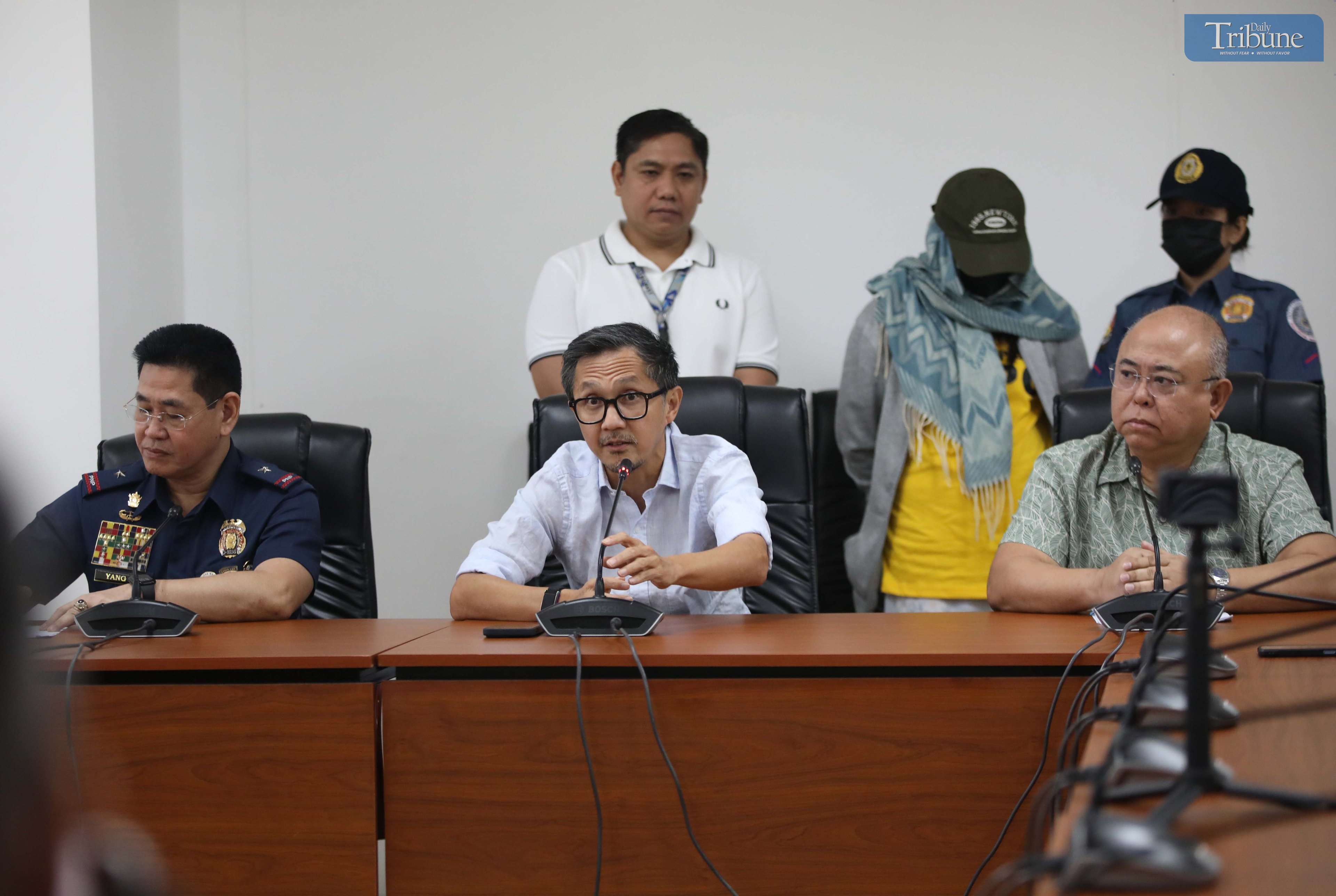 Transport Secretary Vince Dizon, LTO Chief Asec. Vigor Mendoza, and PNP Anti-Cybercrime Group head Brig. Gen. Bernard Yang present a woman accused of selling fake PWD and driver’s licenses online, during a press briefing at the DOTr office in San Juan.