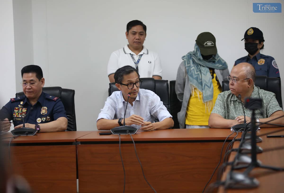 Transport Secretary Vince Dizon, LTO Chief Asec. Vigor Mendoza, and PNP Anti-Cybercrime Group head Brig. Gen. Bernard Yang present a woman accused of selling fake PWD and driver’s licenses online, during a press briefing at the DOTr office in San Juan.