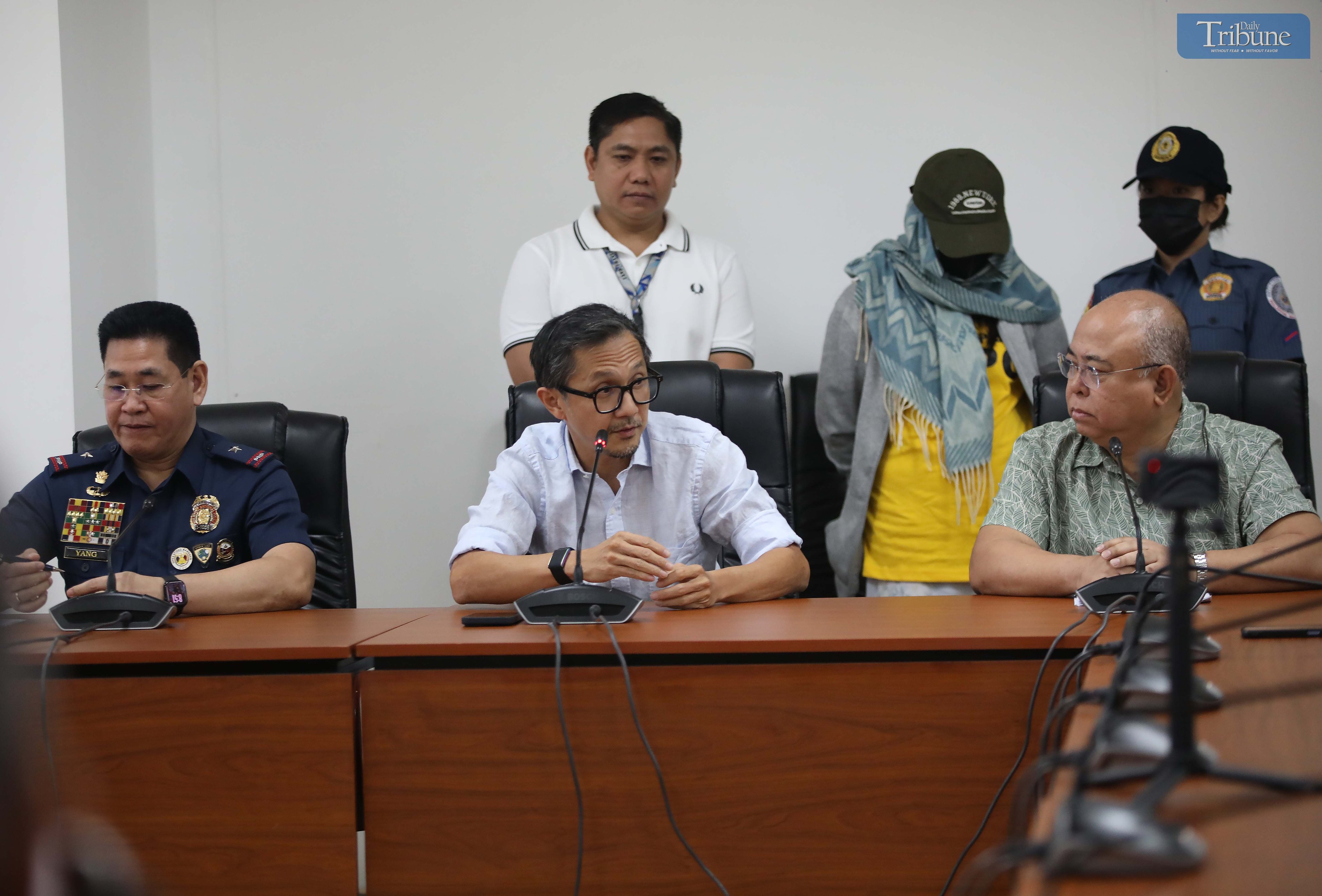 Transport Secretary Vince Dizon, LTO Chief Asec. Vigor Mendoza, and PNP Anti-Cybercrime Group head Brig. Gen. Bernard Yang present a woman accused of selling fake PWD and driver’s licenses online, during a press briefing at the DOTr office in San Juan.