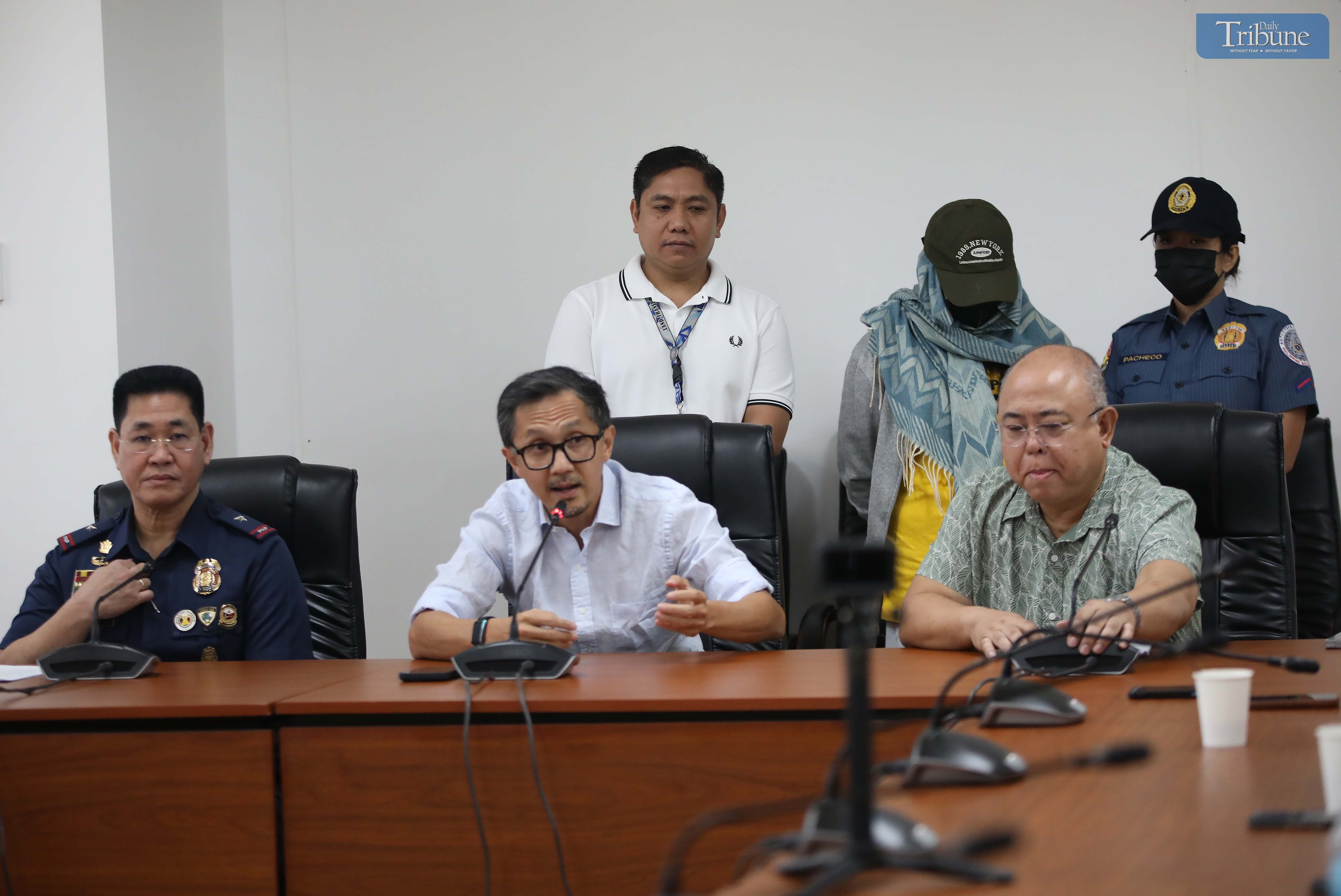 Transport Secretary Vince Dizon, LTO Chief Asec. Vigor Mendoza, and PNP Anti-Cybercrime Group head Brig. Gen. Bernard Yang present a woman accused of selling fake PWD and driver’s licenses online, during a press briefing at the DOTr office in San Juan.