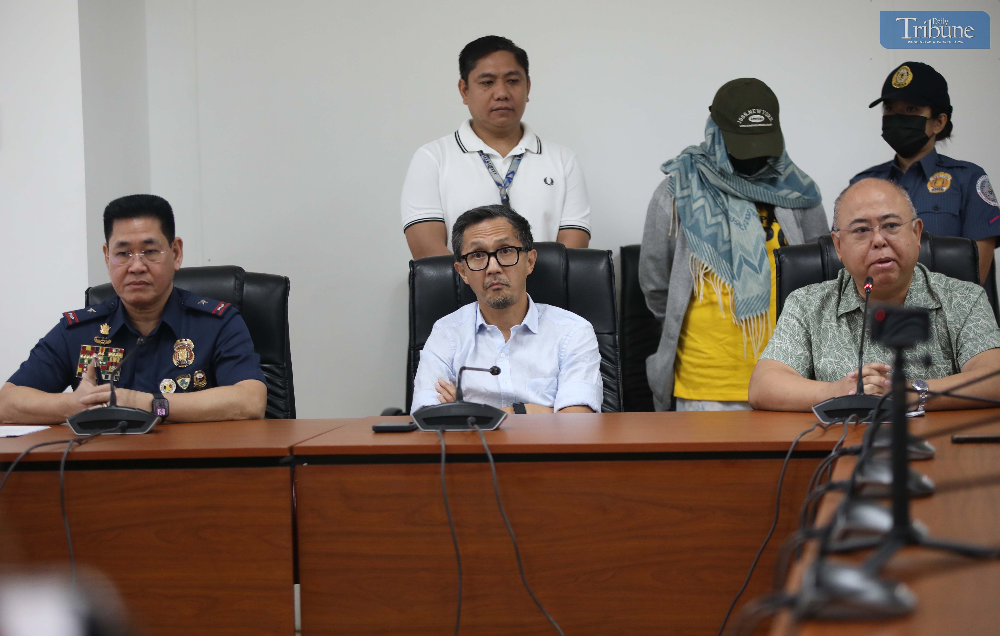 Transport Secretary Vince Dizon, LTO Chief Asec. Vigor Mendoza, and PNP Anti-Cybercrime Group head Brig. Gen. Bernard Yang present a woman accused of selling fake PWD and driver’s licenses online, during a press briefing at the DOTr office in San Juan.