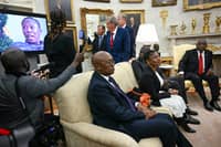 South African President Cyril Ramaphosa looks on as a controversial video is played during his meeting with U.S. President Donald Trump in the Oval Office of the White House in Washington, DC, on 21 May 2025. The video, part of a tense discussion, featured inflammatory claims about white Afrikaner farmers, which Trump has falsely labeled as victims of "genocide."