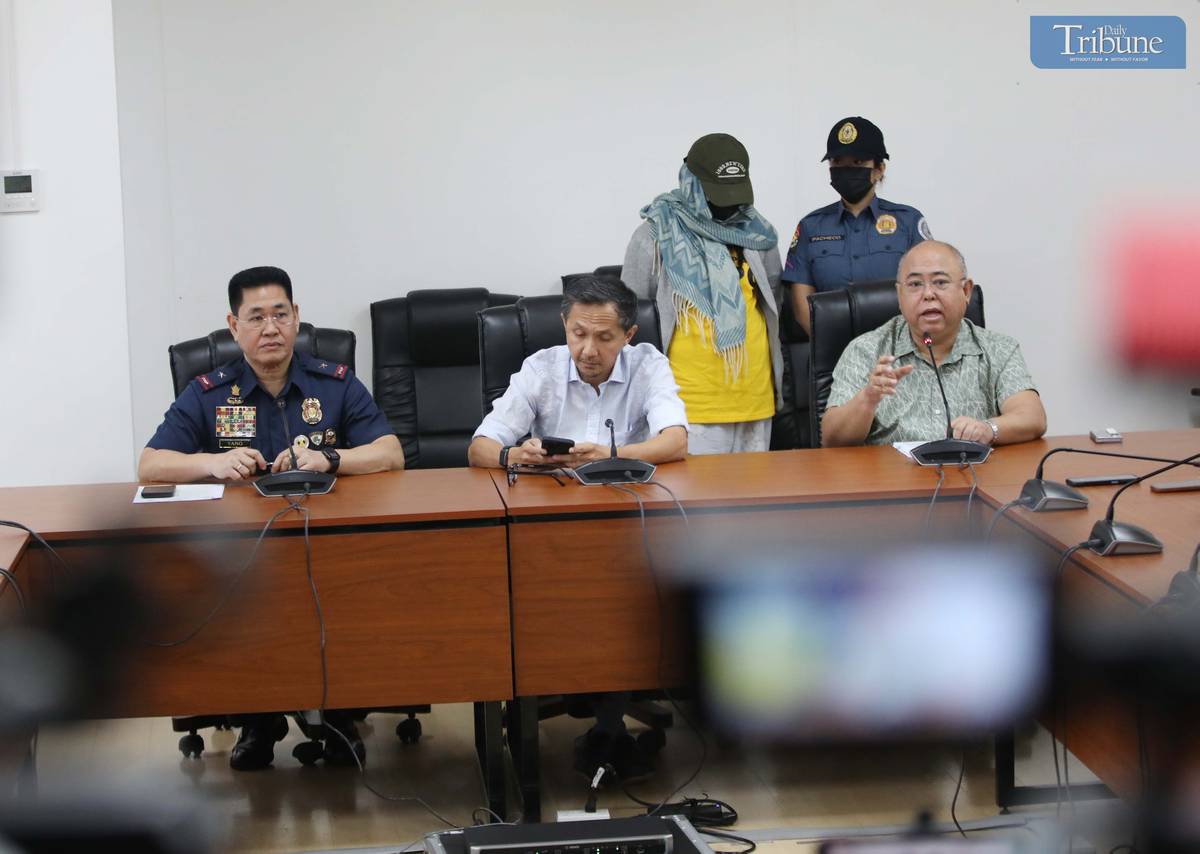 Transport Secretary Vince Dizon, LTO Chief Asec. Vigor Mendoza, and PNP Anti-Cybercrime Group head Brig. Gen. Bernard Yang present a woman accused of selling fake PWD and driver’s licenses online, during a press briefing at the DOTr office in San Juan.