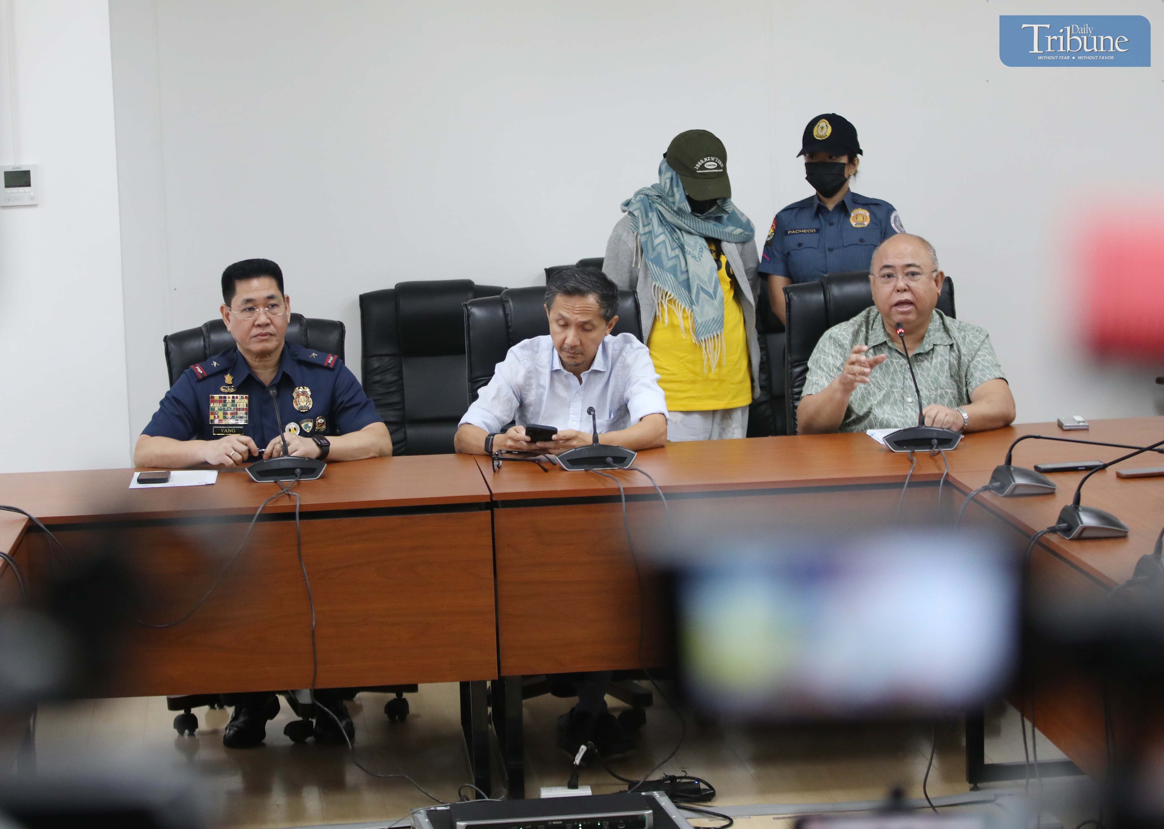 Transport Secretary Vince Dizon, LTO Chief Asec. Vigor Mendoza, and PNP Anti-Cybercrime Group head Brig. Gen. Bernard Yang present a woman accused of selling fake PWD and driver’s licenses online, during a press briefing at the DOTr office in San Juan.