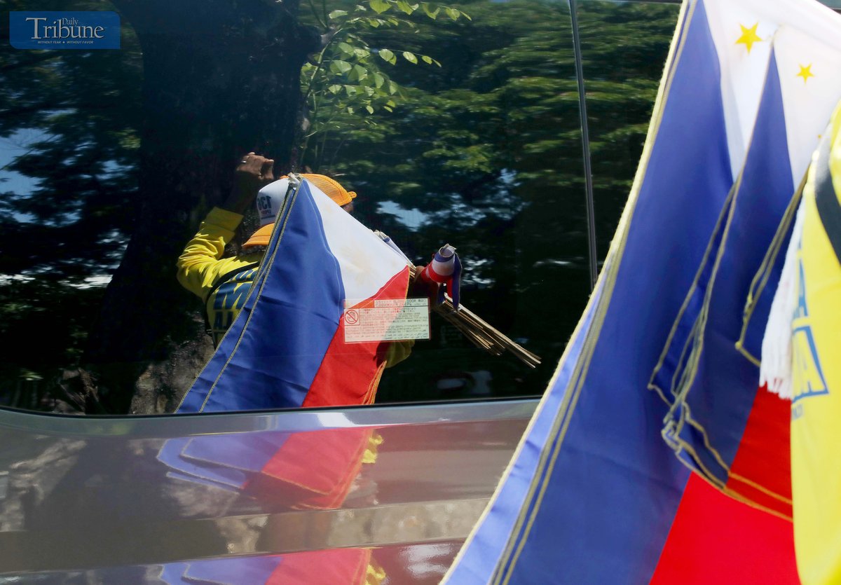 Vendors sell Philippine flags of various sizes to motorists along Commonwealth Avenue in Quezon City on Friday. The country will mark Philippine Flag Day on 28 May, commemorating the flag’s first unfurling in battle during the 1898 Battle of Alapan in Imus, Cavite, shortly before the declaration of independence from Spanish rule.
