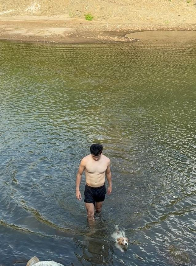 ANDERSON swimming with his dog.