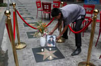 Workers arrange the flower and candle at the star of the late folk singer and OPM icon Freddie Aguilar at the Eastwood City Walk of Fame in Quezon City on Wednesday. Aguilar passed away on 27 May at the age of 72 due to multiple-organ failure.