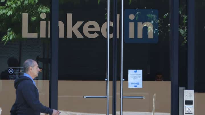 A PEDESTRIAN walks by a sign at a LinkedIn office on July 26, 2023 in San Francisco, California. LinkedIn announced plans to cut nearly 200 jobs at offices in the San Francisco Bay Area. The cuts follow 700 layoffs earlier in the year.