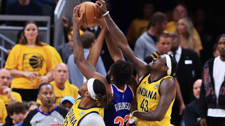 Mitchell Robinson #23 of the New York Knicks drives to the basket against Pascal Siakam #43 and Myles Turner #33 of the Indiana Pacers during the third quarter in Game Six of the Eastern Conference Finals of the 2025 NBA Playoffs at Gainbridge Fieldhouse