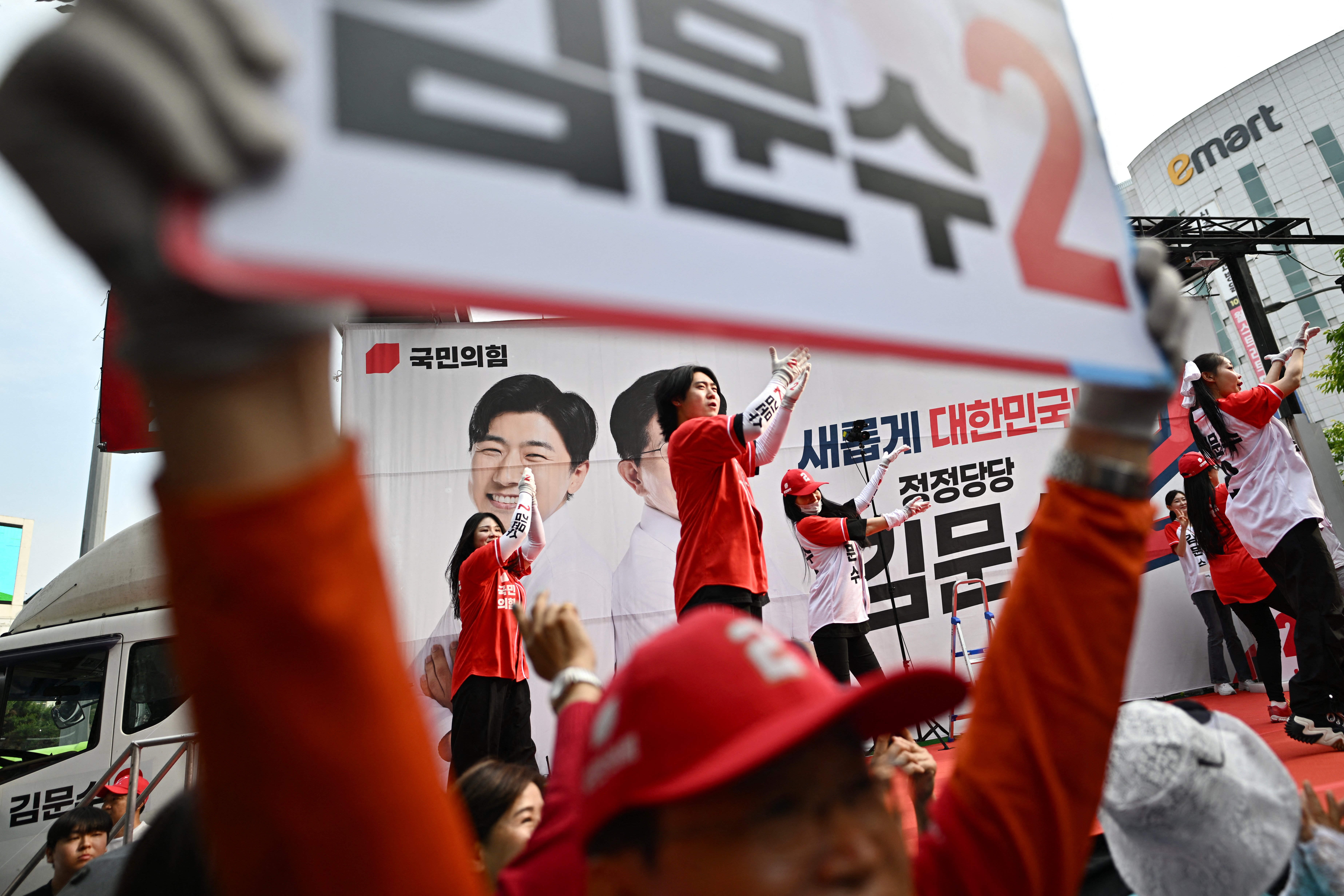 Supporters of South Korean presidential candidate Kim Moon-soo of the People Power Party perform before an election campaign event ahead of the upcoming 3 June presidential election in Seoul.