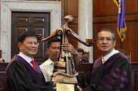 Retiring Supreme Court Associate Justice Mario Lopez (left) receives the symbolic tribute from Chief Justice Alexander Gesmundo during a special en banc session for his ceremonial retirement.