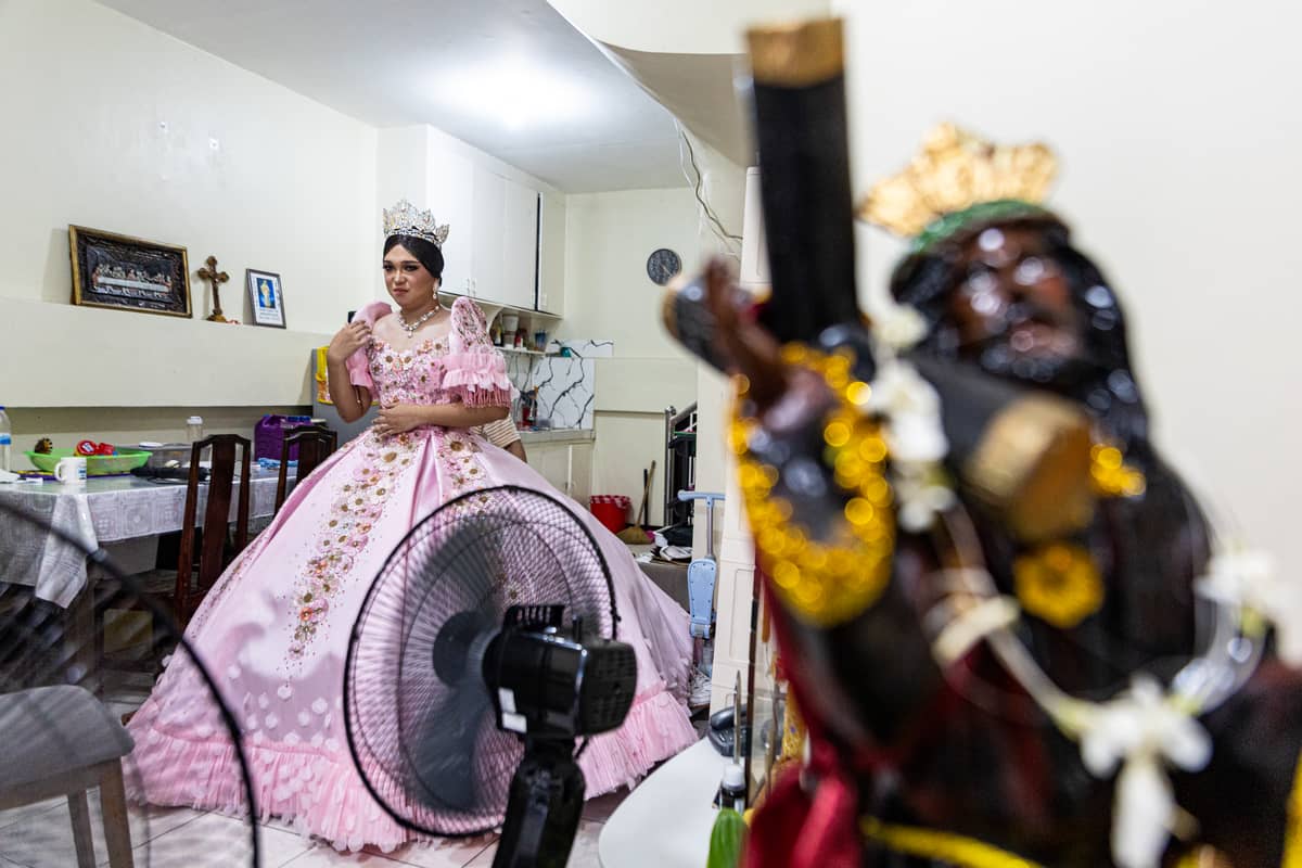Andrei Cruz looks at himself in the mirror after wearing his gown for the Sagayla procession in Sampaloc, Manila, on Sunday, June 1, 2025.