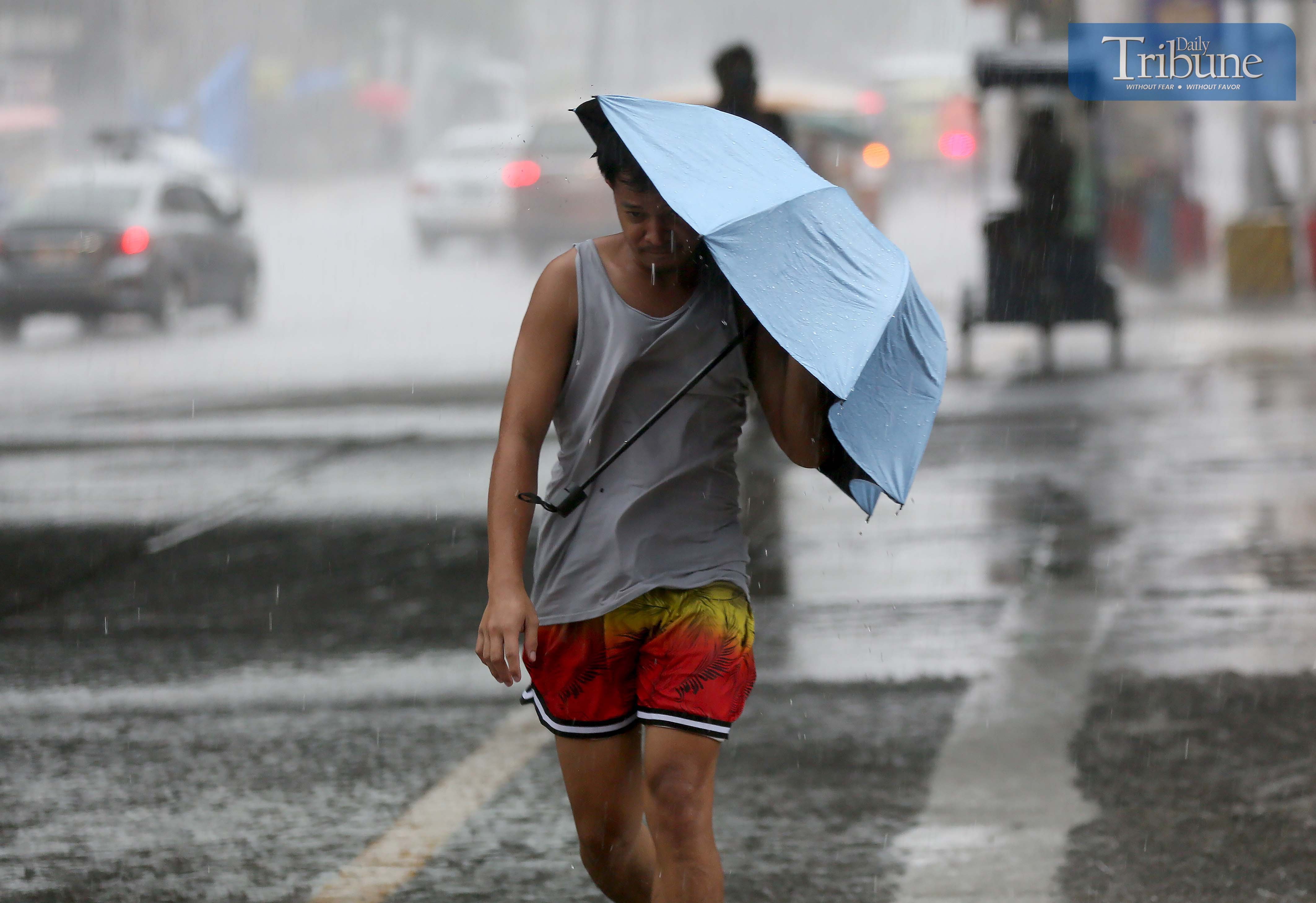 A PEDESTRIAN shields himself from a sudden downpour with an  umbrella which appears to have seen better days on Friday 6 June in Quezon City. PAGASA says moderate to heavy rains with thunderstorms and strong winds are expected today over  Zambales, Quezon, Cavite, Batangas, Laguna, Metro Manila and Rizal.