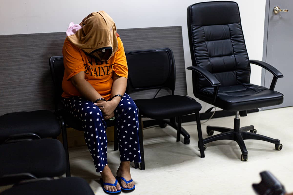 Members of the National Bureau of Investigation-International Airport Investigation Division present the arrested employee assigned at Ninoy Aquino International Airport Terminal 3 for alleged human trafficking during a briefing in Pasay City. The suspect allegedly provided a fraudulent Bureau of Immigration border stamp and boarding pass to facilitate her victims’ illegal departure in exchange for money.