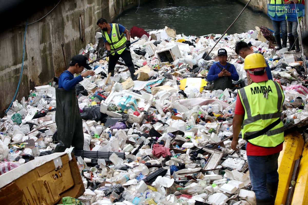Metropolitan Manila Development Authority (MMDA) workers use both manual tools and a backhoe to remove trash from Maligaya Creek in Caloocan on Wednesday, as part of Bayanihan sa Estero—an ongoing cleanup drive aimed at clearing Metro Manila waterways to help prevent flooding.