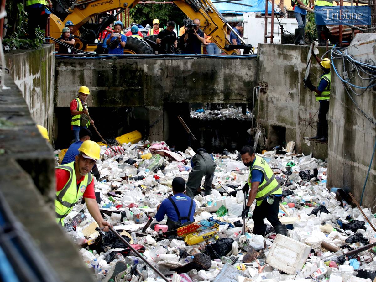 Metropolitan Manila Development Authority (MMDA) workers use both manual tools and a backhoe to remove trash from Maligaya Creek in Caloocan on Wednesday, as part of Bayanihan sa Estero—an ongoing cleanup drive aimed at clearing Metro Manila waterways to help prevent flooding.