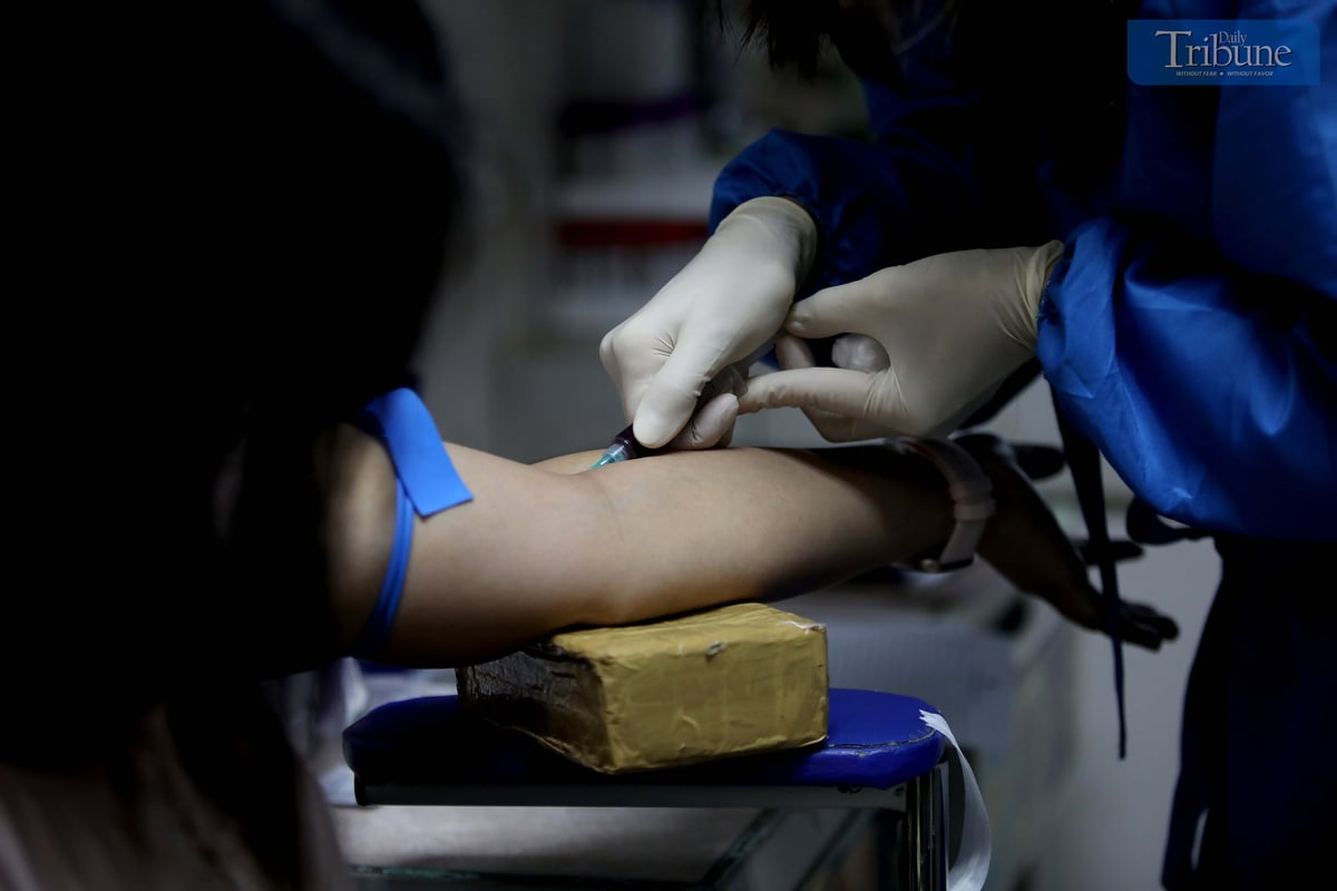 A HEALTH worker collects a blood sample from a patient undergoing HIV testing as part of work requirements at the Social Hygiene Clinic in Project 7, Quezon City. The Department of Health has called for a national public health emergency following a report that HIV cases among young Filipinos have surged by 500 percent.